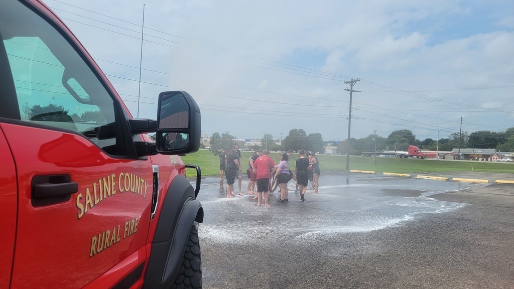 fire department spraying band camp members in parking lot